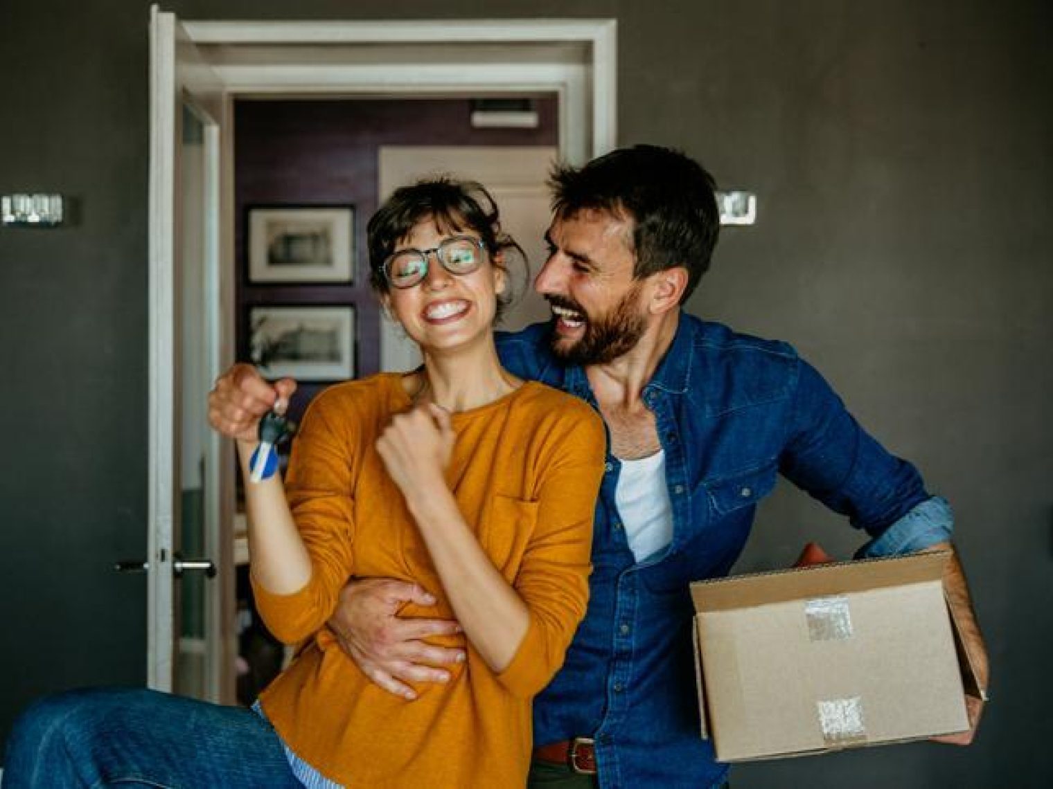 A delighted couple with new home keys, symbolizing the joy of homeownership.